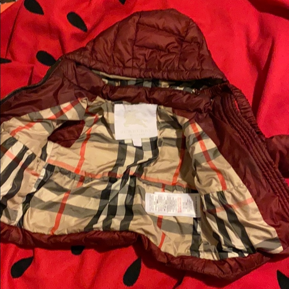 slight tear at the bottom of coat near zipper